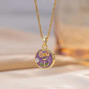 Detail macro view of a gold-plated flower pendant necklace with purple enamel rose and pearl