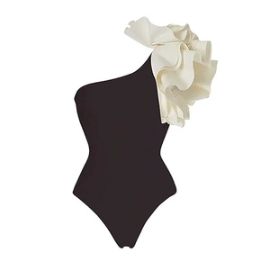 Detail of one-shoulder swimsuit with elegant layered white ruffles on black fabric