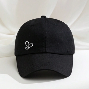 Classic black cotton baseball cap with white heart embroidery on a soft fabric backdrop