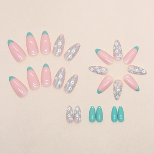Almond-shaped press-on nails with soft pink base, floral patterns, and green accents