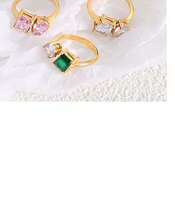 Detail of adjustable gold rings featuring square-cut pink, white, and green crystals