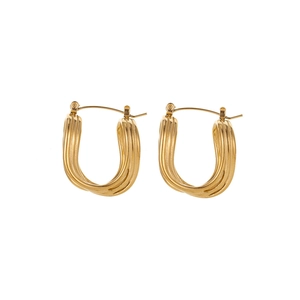 Macro shot of gold-plated U-shaped earrings with twisted spiral texture on white background