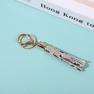 Détail du porte-clés doré avec pendentif à franges en cuir à motif de peau de serpent