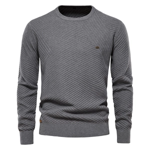 Detail shot of grey men's crewneck sweater featuring a textured geometric knit pattern