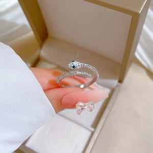 Detail of silver snake ring with green eyes and sparkling crystals on open band