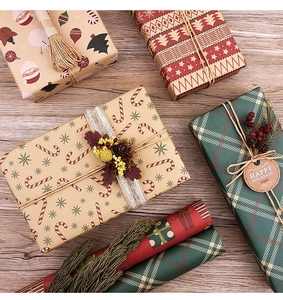 Detail of Christmas kraft wrapping paper featuring reindeer and snowflakes with twine