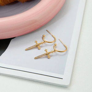 Detailed view of 18k gold plated cross sword earrings with inlaid zircon crystals