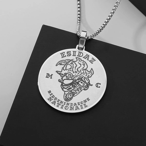 Macro shot of silver punk pendant featuring intricate engraving on black display stand