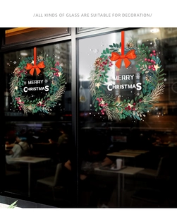 Macro detail of Christmas wreath glass decals with red bows and Merry Christmas lettering