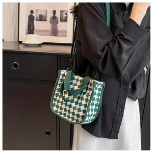 Detail of green and white checkered knit tote bag with detachable shoulder strap and handles