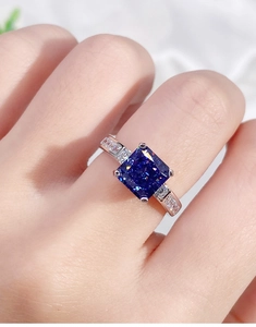 Detailed close-up of a 925 silver ring with a blue square gemstone on a model finger