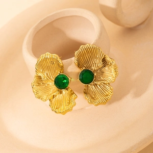 Retro gold plated flower earrings with emerald green stone on ceramic tray