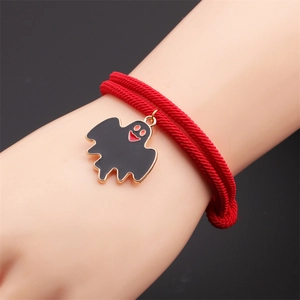 Detail of red woven bracelet featuring a black enamel ghost charm with gold alloy accents