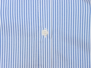 Detail of blue and white vertical striped shirt fabric with a white four-hole button