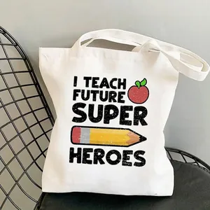 Detail of white canvas tote bag with I Teach Future Super Heroes print and pencil graphics