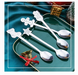 Christmas stainless steel spoons with snowman and gingerbread man on a ceramic tray