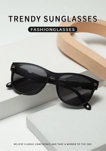 Detail view of oval sunglasses with golden hinge accents on white geometric stand