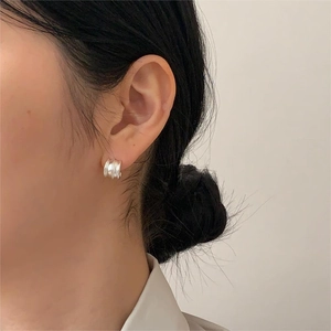 Detailed view of wide triple-layered 925 sterling silver geometric hoop earrings on a model