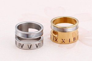 Close-up of gold and silver stainless steel rings with shell inlay and Roman numerals
