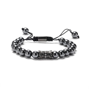 Braided men's bracelet with black beads and a crown charm on a white background