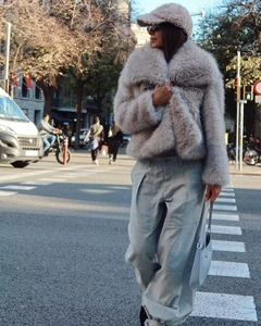 Street style shot of a woman in a gray faux fur coat and matching wide-leg trousers