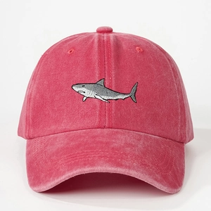 Detailed close-up of a pink washed cotton baseball cap with shark embroidery