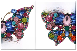 Close-up of butterfly brooch with colorful glass crystals and high-light rhinestones