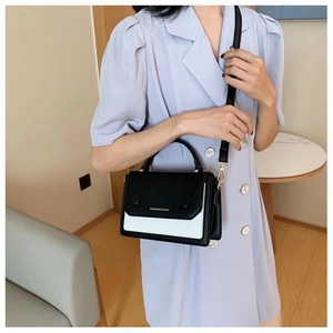 Detail of a black and white contrast leather crossbody bag with detachable shoulder strap