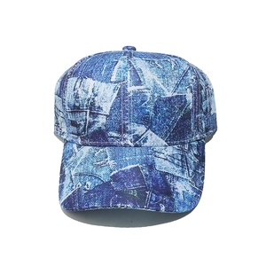 Close-up detail of blue denim textured fabric and six-panel stitching on baseball cap