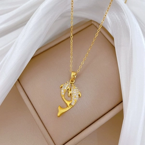 Macro shot of gold dolphin necklace with sparkling pavé crystals in a jewelry box