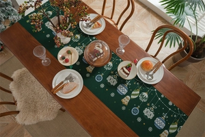 Festive Christmas table runner with ornaments and snowflakes on a green jacquard background