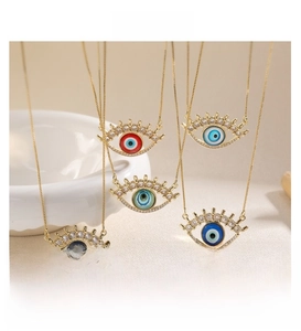 Detail of five evil eye necklaces in gold with multicolored zircons and eyelash design