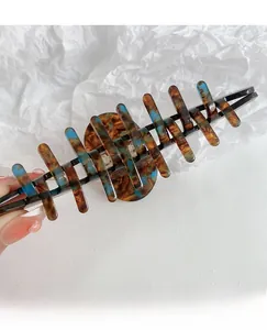 Dettaglio macro di una grande molletta per capelli con motivo marmorizzato blu e marrone