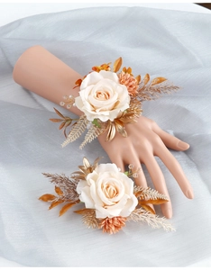 Détails de corsages de poignet avec roses crème et décorations de feuilles dorées