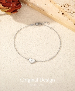 Détail du bracelet en argent S925 avec cœur et moissanite couleur D sur fond texturé