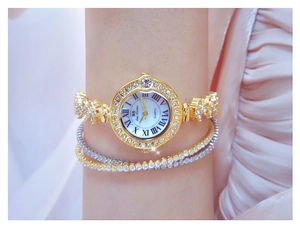 Elegant gold quartz watch with crystal bezel and Roman numerals on a woman's wrist