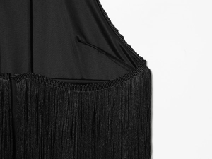 Detailaufnahme eines schwarzen Samt-Halternecks mit dichten langen Fransen und Seidentextur