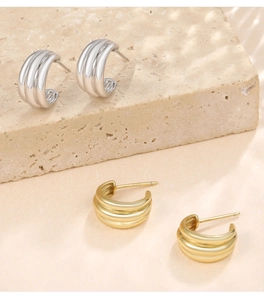 Detailed macro view of S925 sterling silver C-shaped ribbed earrings in gold and silver