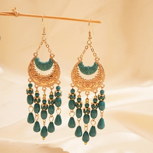 Detail of vintage bohemian chandelier earrings with green beads and gold hollow crescent