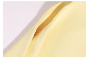 Detailed close-up of light yellow sports bra fabric with fine texture and matte finish