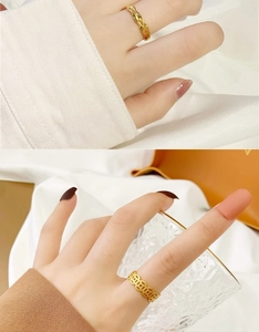 Detail of twisted rope ring and hollow coin design gold ring on finger with silk