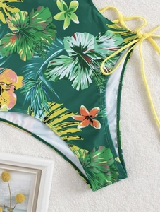 Detail of high waisted tropical print swimsuit with yellow side lace-up ties and floral pattern