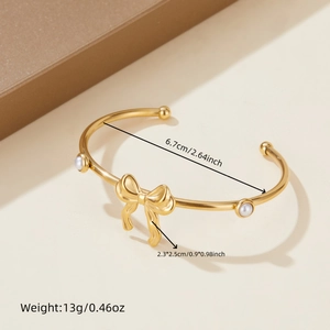 Gold-plated stainless steel open bangle with pearl accents and bow charm detail