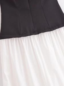 Detailed close-up of the black bodice and white pleated skirt fabric stitching