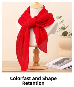 Détail de la texture d'une écharpe plissée rouge sur mannequin dans un décor chaleureux
