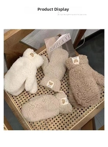 Three colors of plush winter mittens with bear patches on a rustic woven background