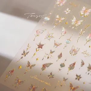 Detailed view of floral and butterfly nail art stickers with elegant gold foil contours