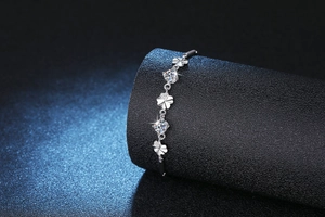 Detail of s925 silver bracelet featuring sparkling clover charms with 1ct moissanite stones