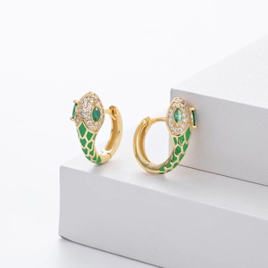 Macro detail of gold snake earrings with green enamel scales and zircon stone inlays