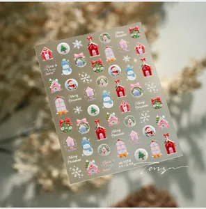 Détail de stickers à ongles de Noël avec bonhommes de neige et motifs de maison en 3D